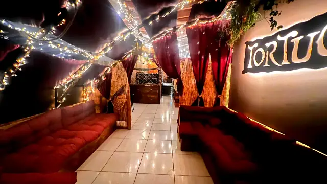 Area lounge del Tortuga illuminata da luci calde